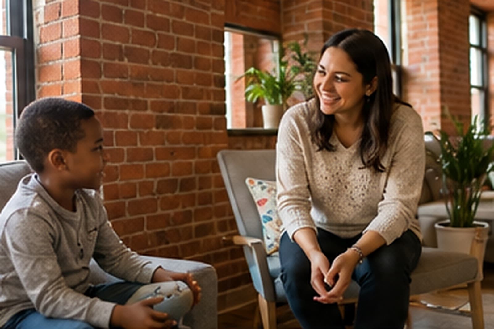 A therapist talking with a smiling boy in a Baltimore rowhome living room
